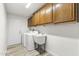 Laundry room with washer, dryer, utility sink, and wood cabinets at 14313 W Circle Ridge Dr, Sun City West, AZ 85375