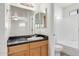Bathroom with wood cabinets, granite countertop, and shower/tub combo at 2228 N 52Nd St # 240, Phoenix, AZ 85008