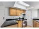 Kitchen with wood cabinets, black countertops and stove at 2228 N 52Nd St # 240, Phoenix, AZ 85008
