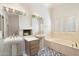 Bathroom with double sinks, bathtub, and fireplace at 7272 E Gainey Ranch Rd # 91, Scottsdale, AZ 85258