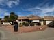 Spanish-style home with tile roof, lush landscaping, and a two-car garage at 13912 W Pavillion Dr, Sun City West, AZ 85375