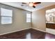 Bright bedroom with dark wood floors, ceiling fan, and access to bathroom at 17957 W Fairview St, Goodyear, AZ 85338