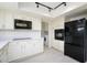 Modern kitchen with white cabinets, stainless steel appliances, and a view of the laundry room at 2717 E Cinnabar Ave, Phoenix, AZ 85028