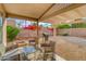 Covered patio with seating area and built-in grill, overlooking a gravel backyard at 3145 E Desert Ln, Gilbert, AZ 85234