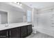 Modern bathroom with dark vanity, bathtub, and shower at 3718 S 58Th Dr, Phoenix, AZ 85043