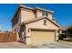 Two-story house with tan exterior, a two-car garage, and a brick paved driveway at 7921 S 26Th Dr, Phoenix, AZ 85041