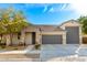 Brick house with gray garage doors and landscaping at 14121 W Crabapple Dr, Surprise, AZ 85387