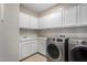 Bright laundry room with washer, dryer, and ample cabinetry at 14121 W Crabapple Dr, Surprise, AZ 85387