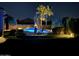 Night view of backyard pool, lounge chairs, and landscape lighting at 24816 S Pleasant Ct, Sun Lakes, AZ 85248