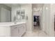 Modern bathroom with white vanity, walk-in closet, and marble floor at 26493 W Piute Ave, Buckeye, AZ 85396