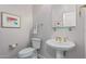 Elegant powder room with pedestal sink, gold fixtures, and a framed piece of art at 4645 W Loma Verde Ave, Eloy, AZ 85131