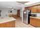 Kitchen features wood cabinets, stainless steel appliances and views to dining area at 4736 W Marconi Ave, Glendale, AZ 85306