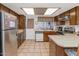 Galley kitchen with wood cabinets, stainless steel appliances, and tile flooring at 4736 W Marconi Ave, Glendale, AZ 85306