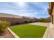 Landscaped backyard with artificial turf and brick pavers at 6509 W Hunter Ct, Phoenix, AZ 85083