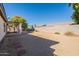 Large backyard with covered patio, gravel, and a block wall at 13478 W Statler St, Surprise, AZ 85374