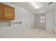 Laundry room with wood cabinets and tile floor at 15008 W Greystone Dr, Sun City West, AZ 85375