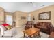 Living room with off-white chair, brown leather furniture, and wooden coffee table at 17770 W Calistoga Dr, Surprise, AZ 85387