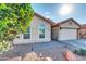 Tan stucco house with tile roof, two-car garage, and landscaped front yard at 1831 E Winged Foot Dr, Chandler, AZ 85249