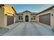 House exterior with a three-car garage and front entrance at 21999 E Camacho Rd, Queen Creek, AZ 85142