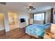 Main bedroom with king bed, TV, and wood floors at 2213 N Park Meadows Dr, Buckeye, AZ 85396