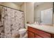 Clean bathroom with wood vanity, shower/tub combo, and decorative shower curtain at 26747 W Pontiac Dr, Buckeye, AZ 85396