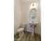 Clean bathroom with pedestal sink, toilet and round mirror at 5532 N 192Nd Ln, Litchfield Park, AZ 85340