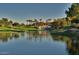 Serene lake view with lush landscaping and a clubhouse in the background at 7272 E Gainey Ranch Rd # 51, Scottsdale, AZ 85258