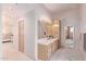 Double vanity bathroom with marble flooring and access to bedroom at 9840 N 111Th Pl, Scottsdale, AZ 85259