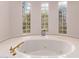 Relaxing bathroom with a large jacuzzi tub and three block windows at 9840 N 111Th Pl, Scottsdale, AZ 85259