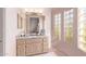 Bathroom with granite vanity, block windows, and light wood cabinets at 9840 N 111Th Pl, Scottsdale, AZ 85259