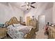 Bedroom with ornate bed, ceiling fan and adjacent sitting area at 9840 N 111Th Pl, Scottsdale, AZ 85259