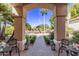 Covered porch with brick flooring, wrought iron chairs, and landscaping at 9840 N 111Th Pl, Scottsdale, AZ 85259