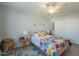 Bedroom with floral bedding, ceiling fan, and wood-look floors at 10412 W Audrey Dr, Sun City, AZ 85351