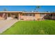 Brick ranch home with a grassy yard and palm trees at 10412 W Audrey Dr, Sun City, AZ 85351