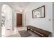 Bright and airy entryway with a wooden bench and mirror at 10714 E Nacoma Dr, Sun Lakes, AZ 85248