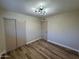 Well-lit bedroom with wood-look floors, neutral walls, and double door closet at 1136 N 84Th Pl, Scottsdale, AZ 85257