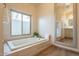 Spa-like bathroom with soaking tub, large mirror, and tile flooring at 16804 E Monterey Dr, Fountain Hills, AZ 85268