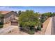 Single-story home with brown garage door and mature tree in front at 44182 W Juniper Ave, Maricopa, AZ 85138