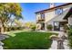 Landscaped backyard with artificial turf, stone pathways, and mature trees at 10191 E Diamond Rim Dr # 2122, Scottsdale, AZ 85255