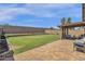 Spacious backyard with covered patio, grassy area, and block wall for privacy at 18110 N Skyhawk Dr, Surprise, AZ 85374