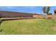 Landscaped backyard with grassy area and retaining wall at 18110 N Skyhawk Dr, Surprise, AZ 85374
