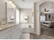 Spa-like bathroom featuring double sinks, a relaxing tub, and access to bedroom at 18110 N Skyhawk Dr, Surprise, AZ 85374