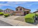 Two-story house with tan exterior, two-car garage, and landscaped front yard at 18110 N Skyhawk Dr, Surprise, AZ 85374