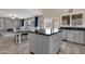 Open kitchen with large island, gray cabinets and a view into the living room at 18110 N Skyhawk Dr, Surprise, AZ 85374