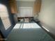 Cozy bedroom featuring a double bed and overhead wooden cabinets at 2205 W Klamath Ave, Apache Junction, AZ 85119