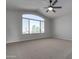 Spacious bedroom with large window, ceiling fan, and neutral carpeting at 8244 W Willow Ave, Peoria, AZ 85381