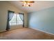 Bright bedroom with light blue walls, a ceiling fan, and neutral carpeting at 1206 E Villa Rita Dr, Phoenix, AZ 85022