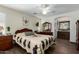 Spacious bedroom with a large bed, wooden dresser, and ceiling fan at 12742 W Ash St, El Mirage, AZ 85335