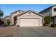 Charming one-story home featuring a pink garage door and a manicured lawn at 12742 W Ash St, El Mirage, AZ 85335