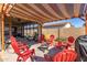 Charming backyard with pergola, fire pit, and red chairs at 13809 W Maui Ln, Surprise, AZ 85379